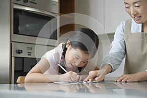 Mother Assisting Girl With Homework