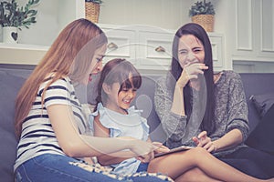 Mother, Aunt and kid having time together lerning with using tablet at home photo