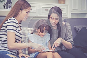 Mother, Aunt and kid having time together lerning with using tabMother, Aunt and kid having time together lerning with using table photo