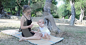 Mother And Baby Boy On Blanket On Grass