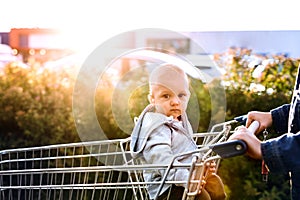 Mother with baby boy going shopping in the car park.