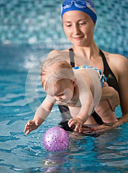 Mother with baby boy in swimming pool training
