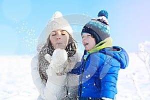 Mother and baby boy in the white snowy day, winter vacation
