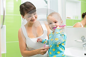 Mother with baby brushing teeth