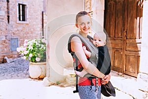 Mother with baby in carrier in the old town of Pula, Croatia.