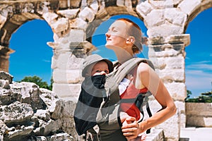 Mother with baby in carrier in the old town of Pula, Croatia.