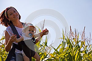 Mother with baby on the corn field