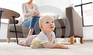 mother and baby crawling on floor at home