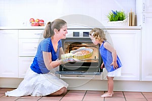 Mother and baby daughter baking a pie