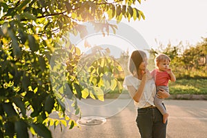 Mother and baby daughter outside in the sunset