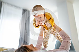 Mother and baby daughter plays, hugging, kissing at home. Happy family.