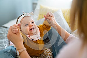 Mother and baby daughter plays, hugging, kissing at home. Happy family.