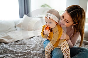 Mother and baby daughter plays, hugging, kissing at home. Happy family.