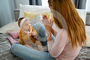 Mother and baby daughter plays, hugging, kissing at home. Happy family.