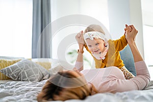 Mother and baby daughter plays, hugging, kissing at home. Happy family.