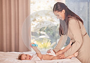 Mother, baby and diaper change on bed for care and wellness of smiling infant son in bedroom. Mom cleaning disposable