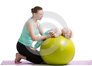 Mother with baby doing gymnastic on ball