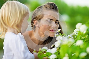 Mother and baby enjoying flowers outdoors