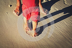 Mother and baby feet walking on beach