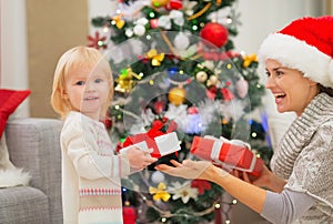 Mother and baby girl changing Christmas presents
