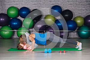 Mother and baby girl do exercises together in the gym