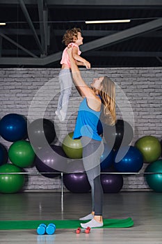 Mother and baby girl do exercises together in the gym