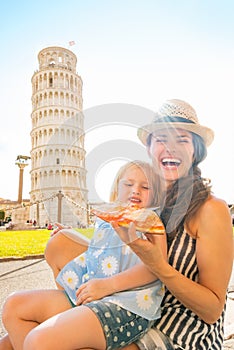 Mother and baby girl eating pizza in pisa