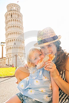 Mother and baby girl eating pizza in pisa