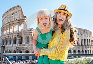 Mother and baby girl in front of colosseum in rome