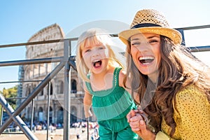 Mother and baby girl in front of colosseum in rome