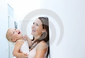 Mother and baby girl laughing together