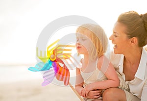 Mother and baby girl playing with windmill toy
