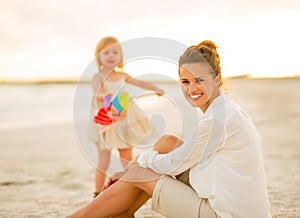 Mother and baby girl spending time on the beach