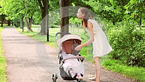 Mother with baby girl in stroller at summer park