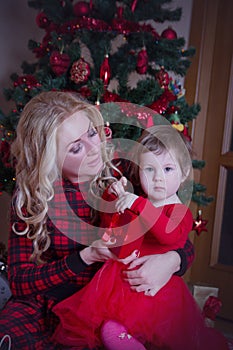 Mother and baby girl under Christmas tree