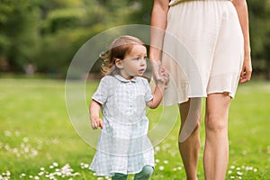 Mother with baby girl walking at summer park