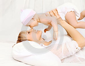 mother and baby having fun at home in the bed