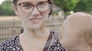 Mother and Baby having fun Outdoors.Together in Green Summer Park. Mom and Child. Happy Family Smiling. Beautiful family