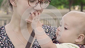 Mother and Baby having fun Outdoors.Together in Green Summer Park. Mom and Child. Happy Family Smiling. Beautiful family