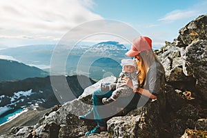 Mother and baby hiking together in mountains family travel outdoor active healthy lifestyle woman with child