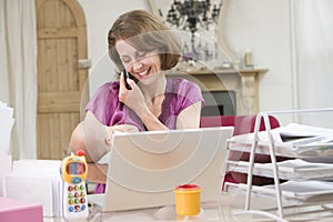 Mother and baby in home office with laptop