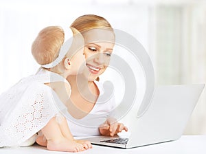 Mother and baby at home using laptop computer