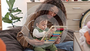 Mother, baby and kid education growth at a house learning numbers on a abacus. Child development experience of a child