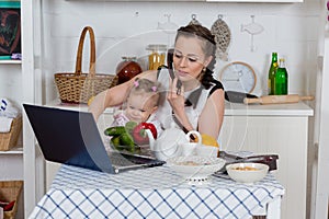 Mother with baby in kitchen.