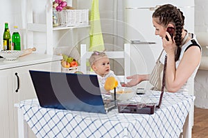 Mother with baby in kitchen.