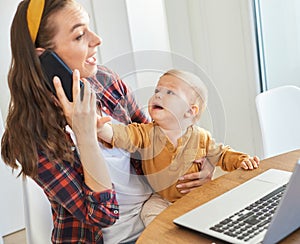 mother baby laptop computer child woman working business mobile phone smartphone parent mom family