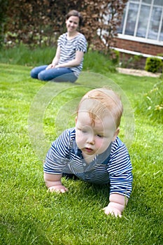 Mother with baby learning to crawl photo