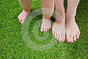 Mother and baby legs standing on grass