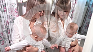 Mother with a baby look in the mirror in bedroom