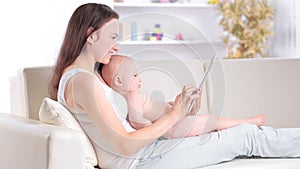 Mother and baby are looking to play and read tablet computer